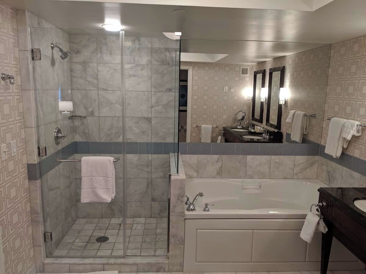 A modern bathroom with a glass-enclosed shower, a freestanding bathtub, and a vanity with a mirror.