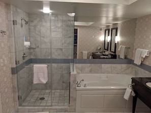 A modern bathroom with a glass-enclosed shower, a freestanding bathtub, and a vanity with a mirror. - 1-bedroom hotel suites - For KINGS (Paradise)