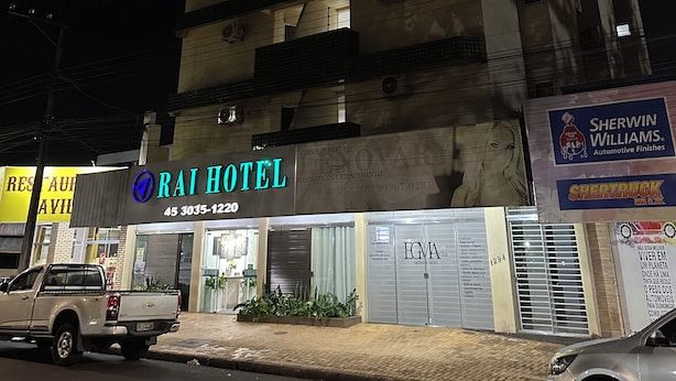 Un edificio de varios pisos con un letrero que dice 'Rai Hotel' al nivel de la calle.