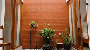 A modern interior with a wooden partition, potted plants, and a seating area.