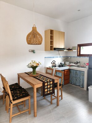 Cozinha moderna com armários de madeira, forno embutido e janela sobre a pia.