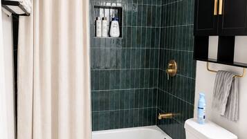 Un baño con bañera, inodoro y cabina de ducha.