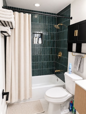 Un bagno con vasca, servizi igienici e zona doccia.