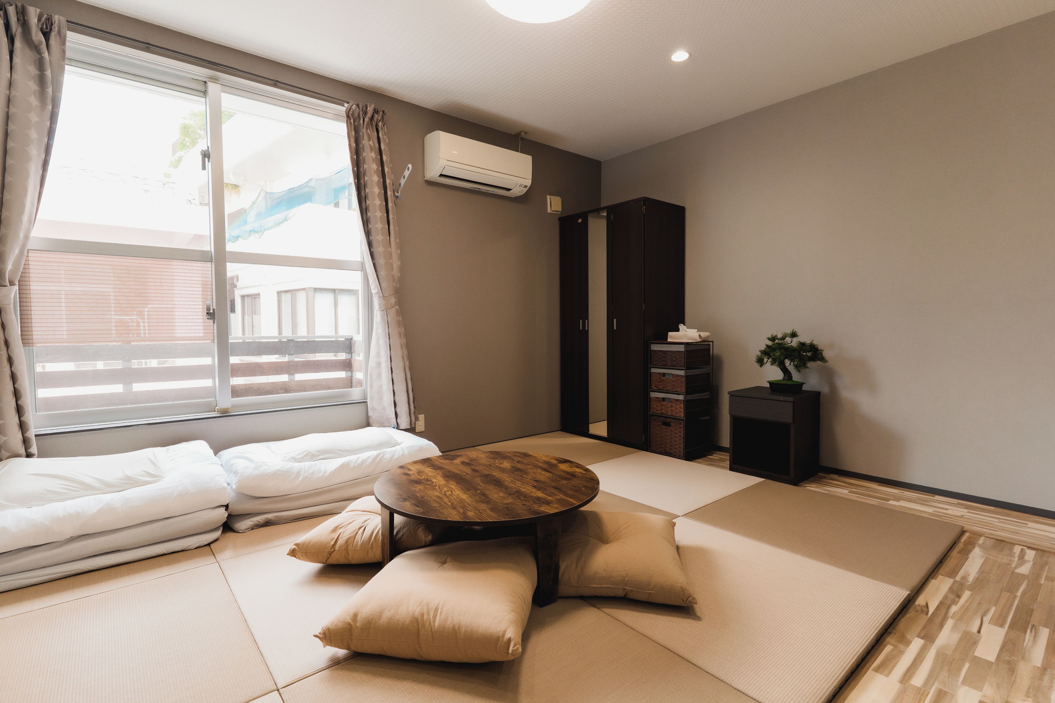 A room with tatami flooring, a low wooden table, and a sofa.