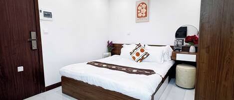 A modern bedroom with a wooden bed, white walls, a small bedside table, and a nightstand.