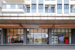 Un edificio moderno con entrada cubierta, amplias ventanas y un cartel que indica 'Tower A'.