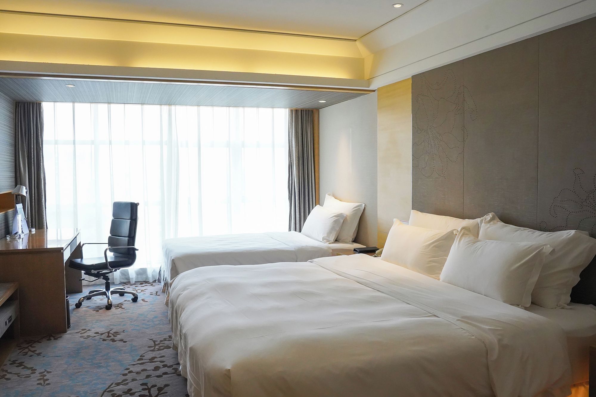 Una habitación de hotel con dos camas, un escritorio y una silla.