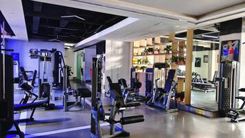 Un gimnasio con equipo de ejercicio variado, incluyendo cintas de correr y máquinas de pesas.