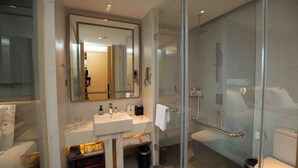 A modern bathroom with a glass shower enclosure, a large mirror, and a marble countertop. - Grand Skylight International Hotel Ganzhou (Ganzhou)
