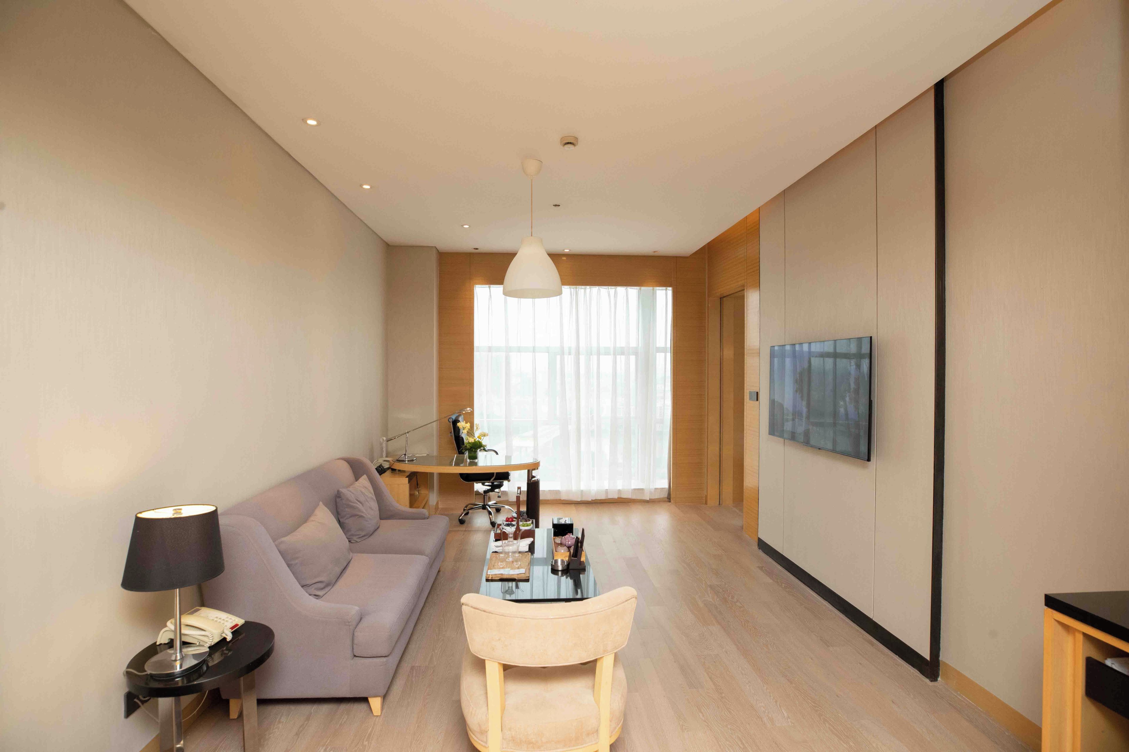 A modern living room with a sofa, coffee table, and TV.