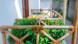 Uma estrutura de recreação de madeira com redes de corda, rodeada por plantas verdes exuberantes.