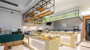 Un buffet moderne proposant une grande variété de plats et un espace dédié aux boissons chaudes.