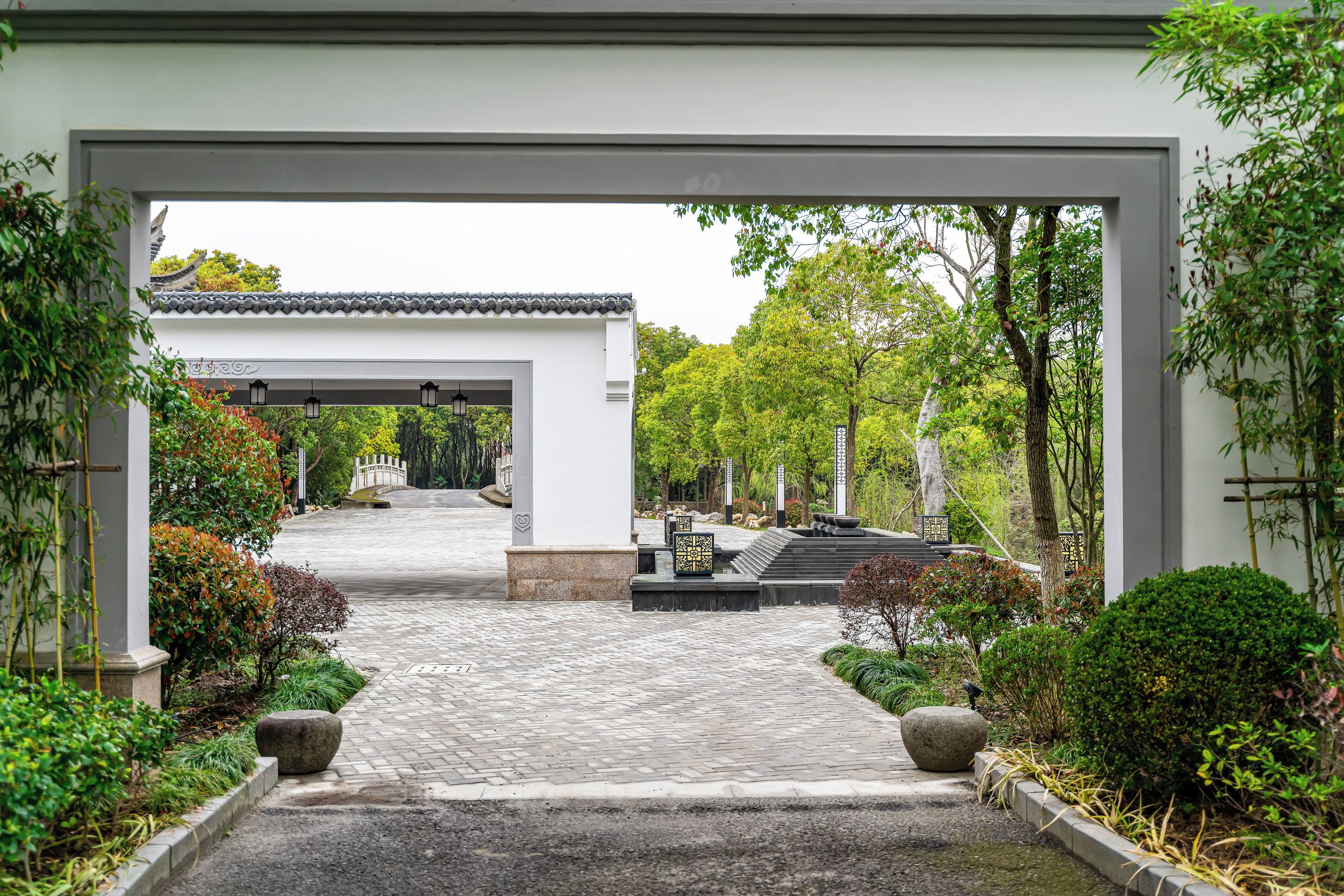 A traditional Japanese garden with a stone pathway leading to a pavilion.