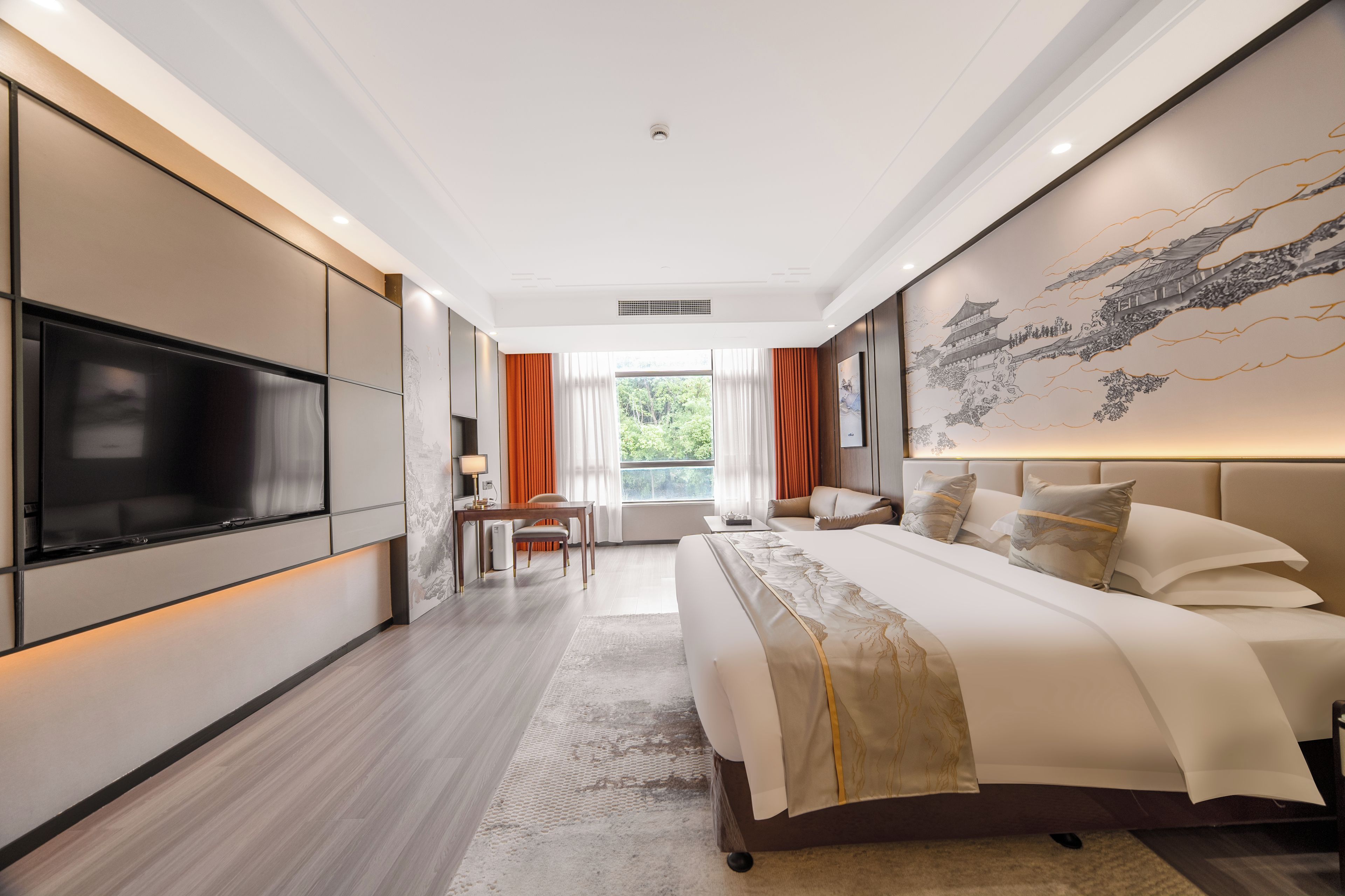 A modern hotel room with a large bed, a flat-screen TV, and a dining area.