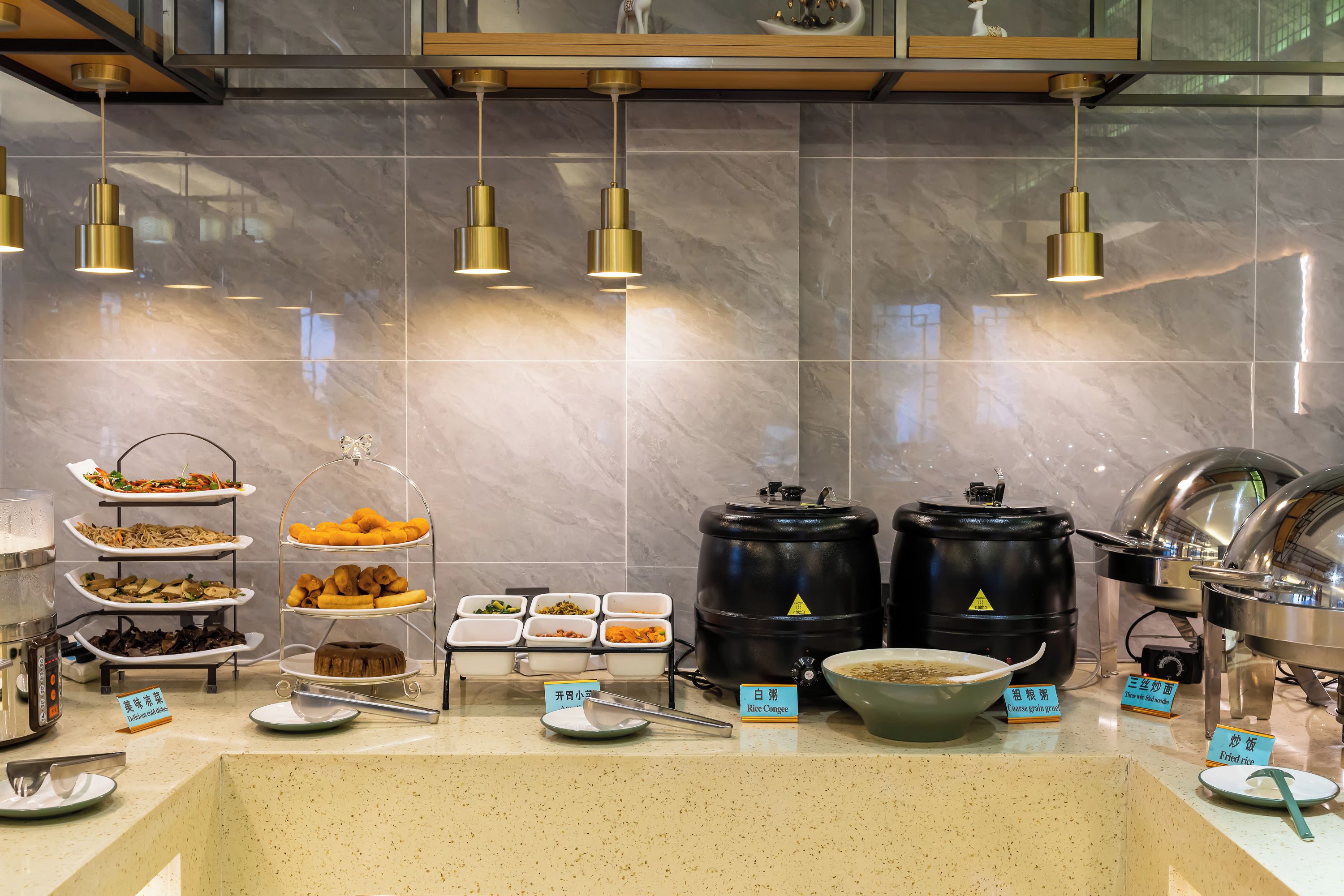 A buffet setup with various food items and serving utensils.