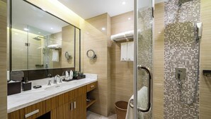 Une salle de bain moderne dotée d’un grand miroir, de deux vasques et d’un espace douche.