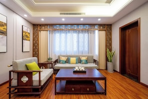 A living room with a sofa set, a coffee table, and a potted plant.