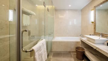 A modern bathroom with a glass-enclosed shower, a standalone bathtub, and a vanity with a large mirror.