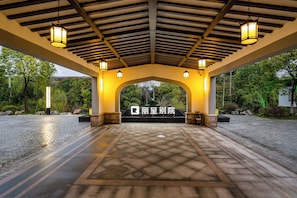 An entrance with a covered walkway, stone flooring, and a sign with Chinese characters.