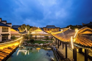 A traditional courtyard with a central water feature, surrounded by buildings with classic architecture.