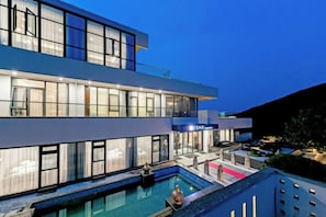 A modern two-story building with a swimming pool and outdoor seating area. - Putuo Mountain Baoning Mountain Residence Hotel (Zhoushan)