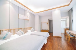 A hotel room with two beds, a wooden floor, a desk, and a mirror. - Putuo Mountain Baoning Mountain Residence Hotel (Zhoushan)