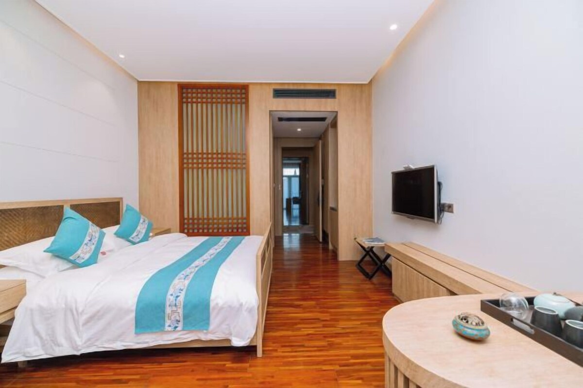Habitació d'hotel amb un llit, una taula de nit i una televisió penjada a la paret.