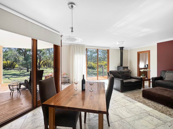 Un salón amplio con una mesa de comedor de madera, un sofá y una chimenea.