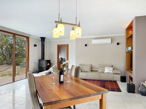A modern living room with a wooden dining table, sofa, and a fireplace.