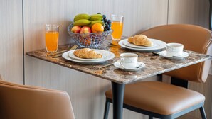 A breakfast table with croissants, fruit, juice, and coffee cups. - High Floor Luxury Burj Khalifa & Canal View Studio (Dubai)