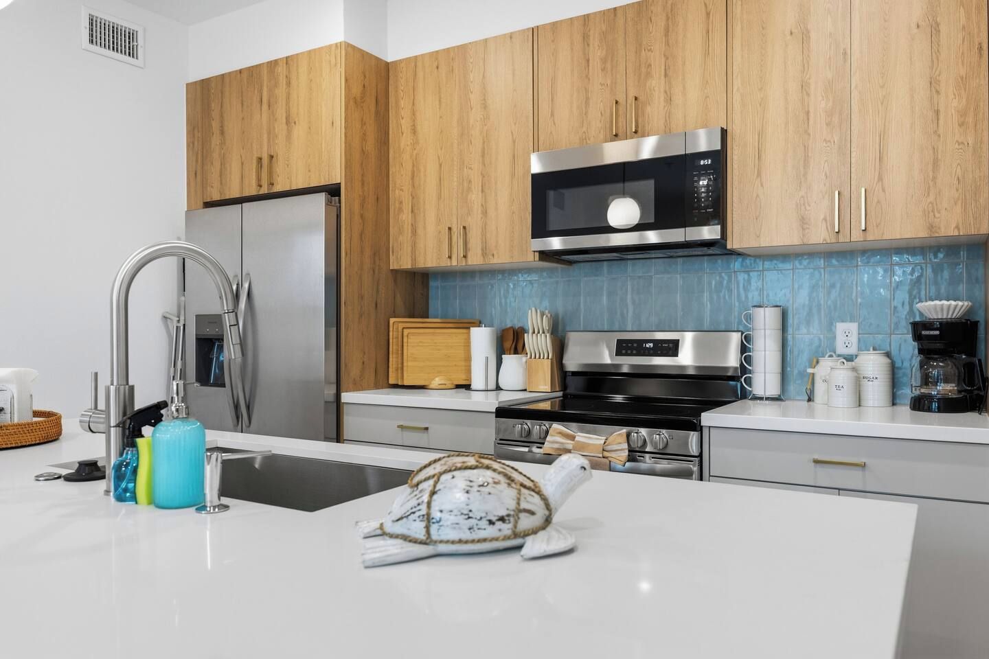 A modern kitchen with wooden cabinets, stainless steel appliances, and a central island.
