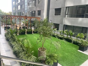 A modern building with a rooftop garden featuring various plants and a wooden pergola structure. - Urban n modern unit just in the heart of Nairobi. (Nairobi)