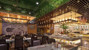 Un restaurante con varias mesas, una zona de bar y un mural en la pared.