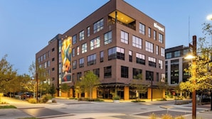 A multi-story building with a prominent 'Dine In' sign, large windows, and a landscaped courtyard. - Coastal Villa Vibes at East River #4 (Houston)