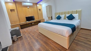 Ein Hotelzimmer mit Bett, Fernseher, Kleiderschrank und Deckenventilator.