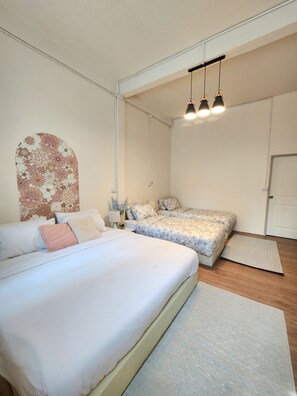 A bedroom with two beds, a nightstand, a lamp, and a decorative wall piece. - 2BR 3-Story Home, Walk to BTS and Sathorn Pier, Free Netflix (Yan Nawa, Sathon)