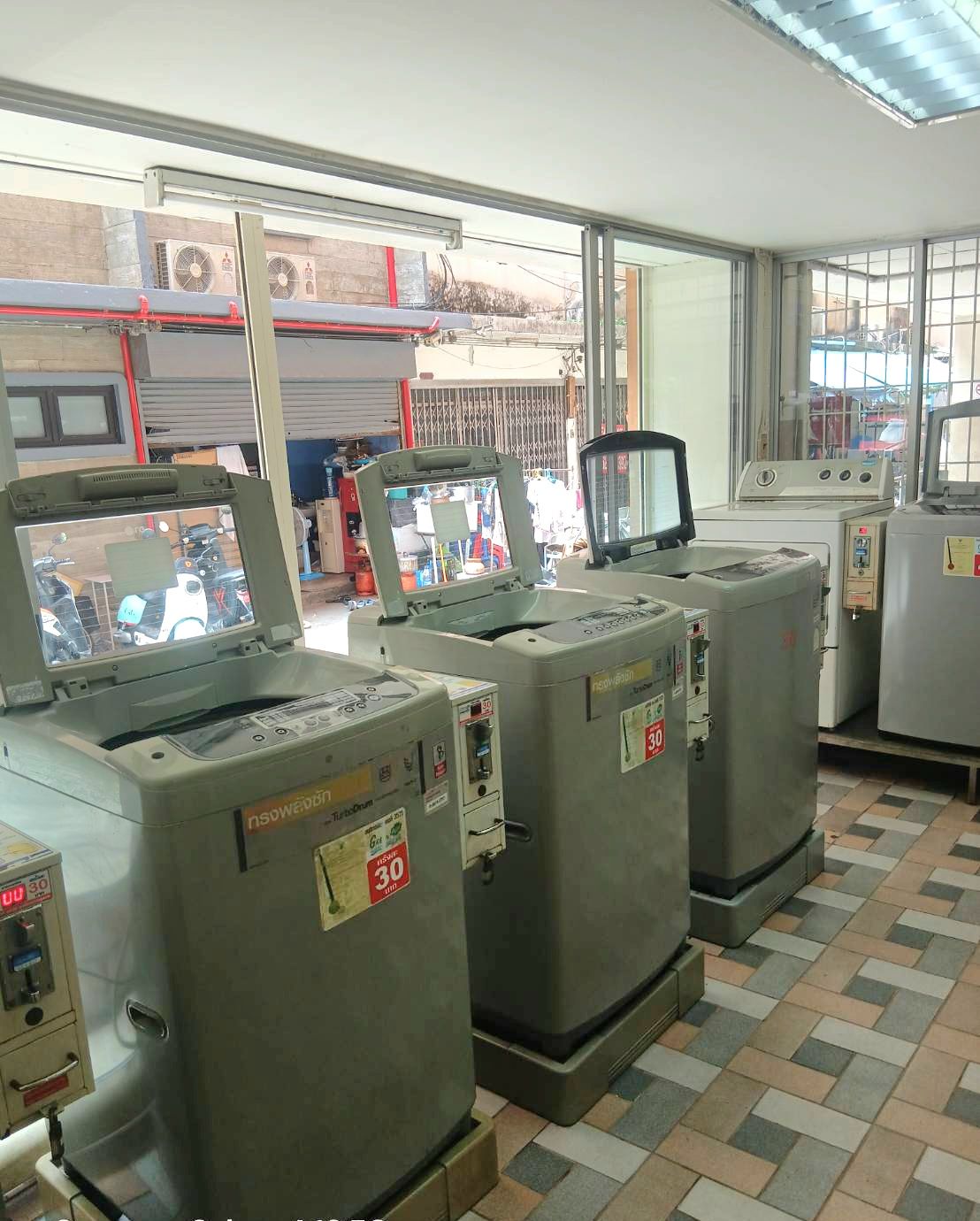 A control room with large industrial machines, a window with a view of the outside, and a tiled floor.