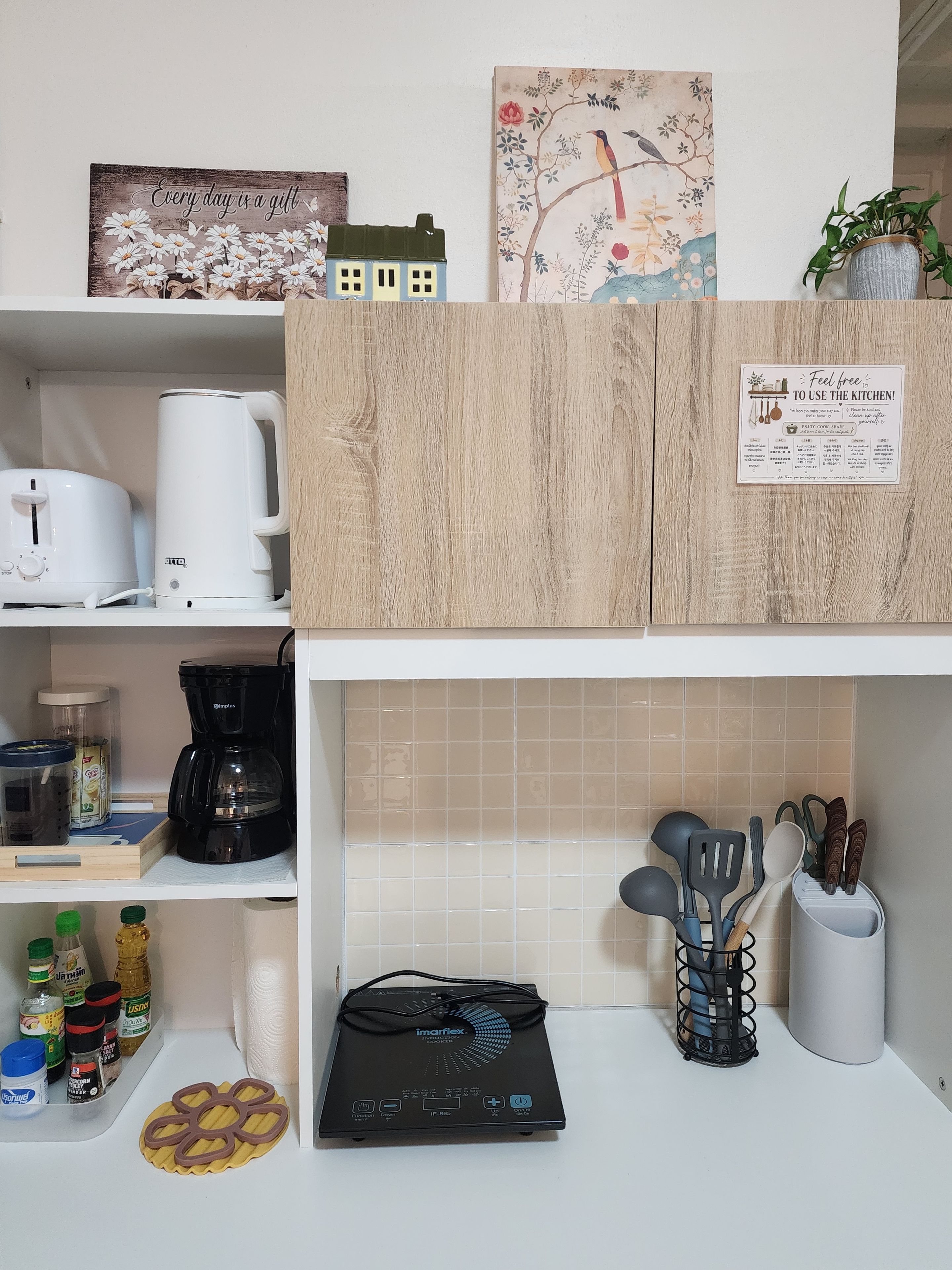 A kitchen with a coffee maker, a scale, and various kitchen utensils.