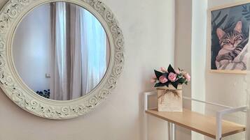 A mirror with an ornate frame, a wooden shelf with a tissue box, and a framed picture on the wall.