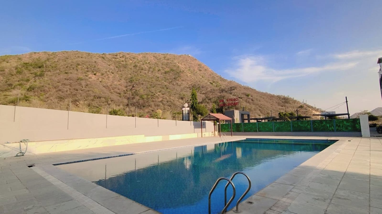 Una piscina con vistas despejadas a un paisaje montañoso al fondo.