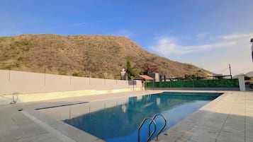Una piscina con vistas despejadas a un paisaje montañoso al fondo.