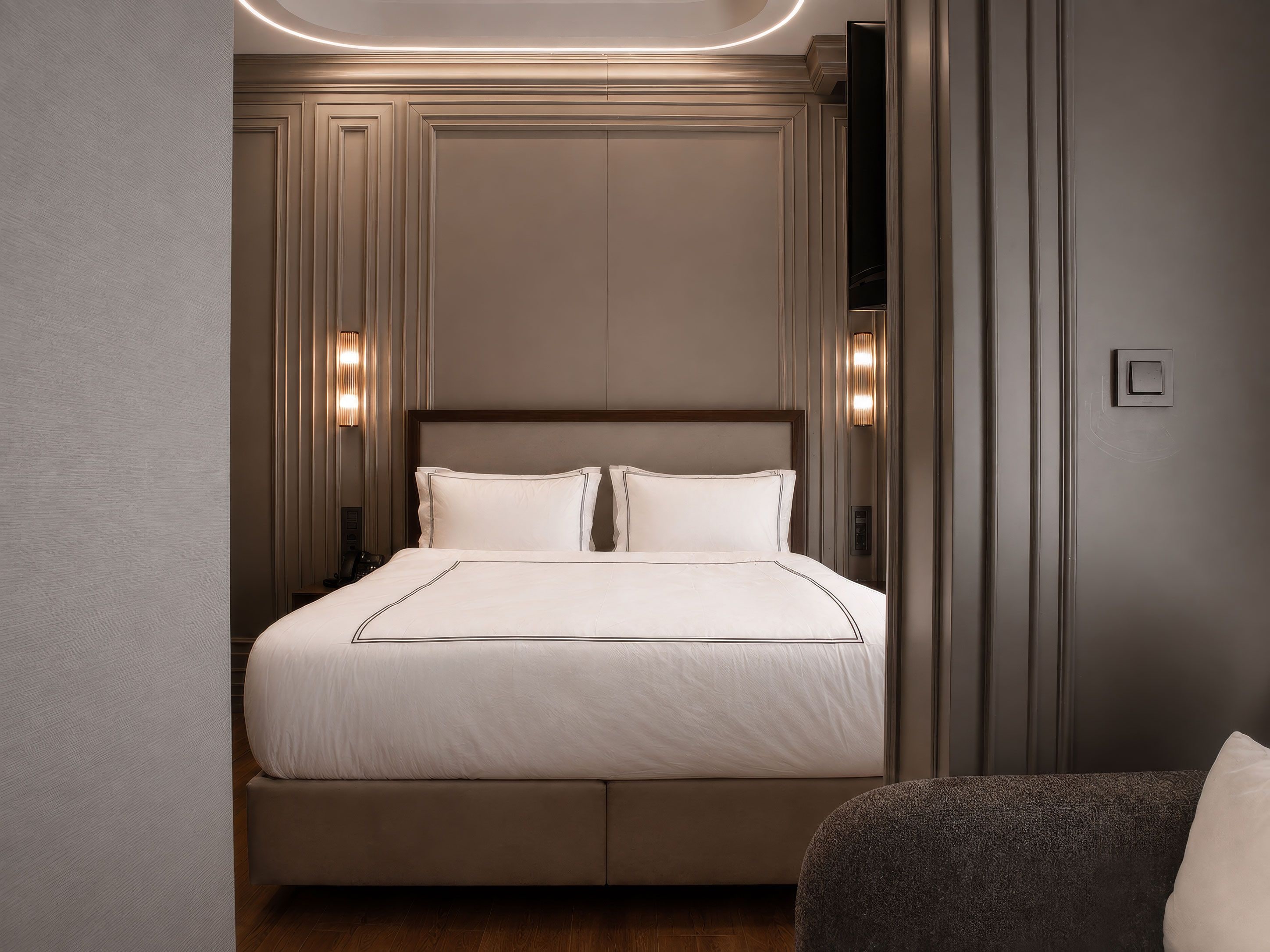 A hotel room with a large bed, two bedside lamps, and a modern design.