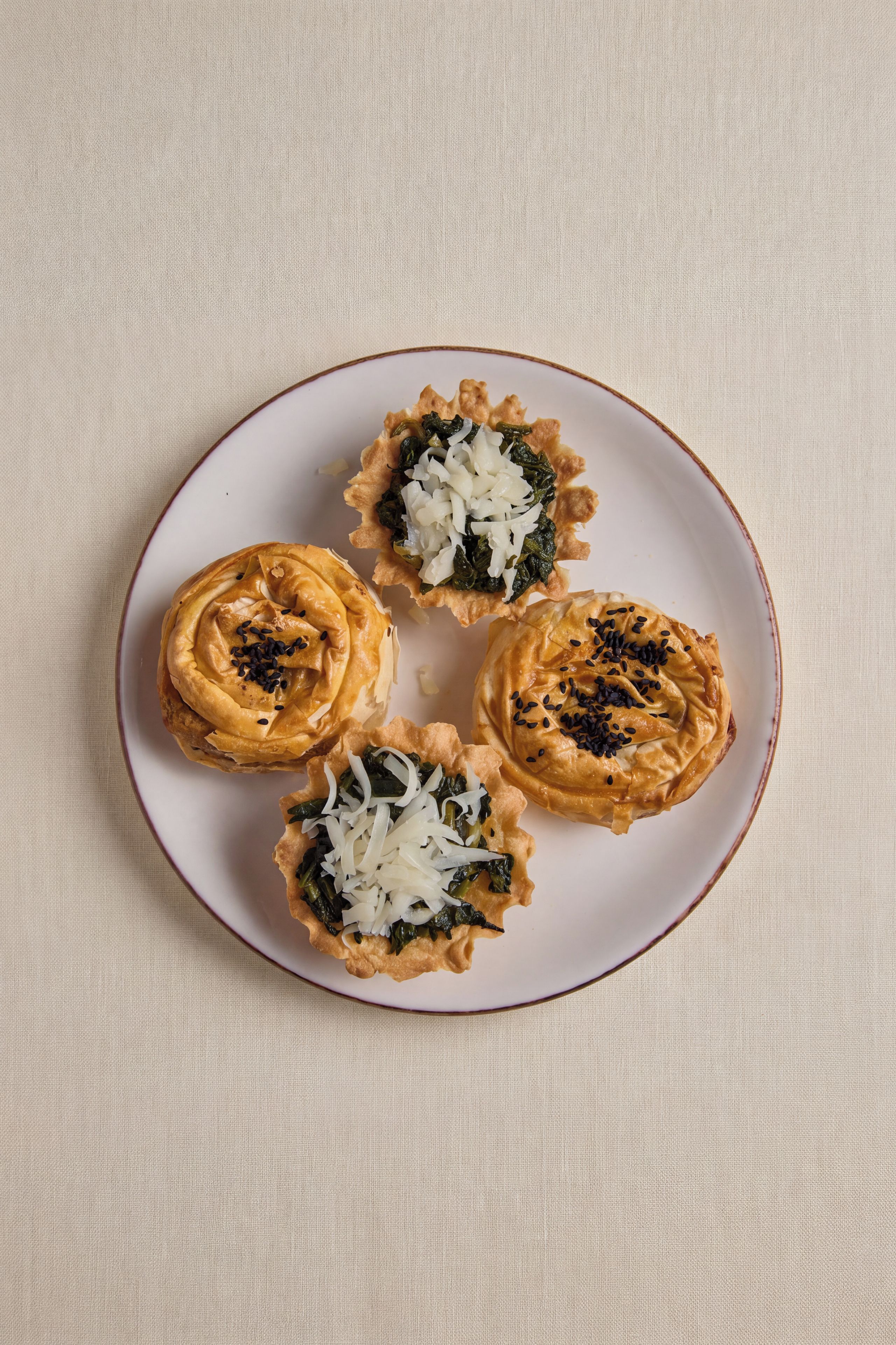 Un piatto con quattro pasticcini su una superficie strutturata.
