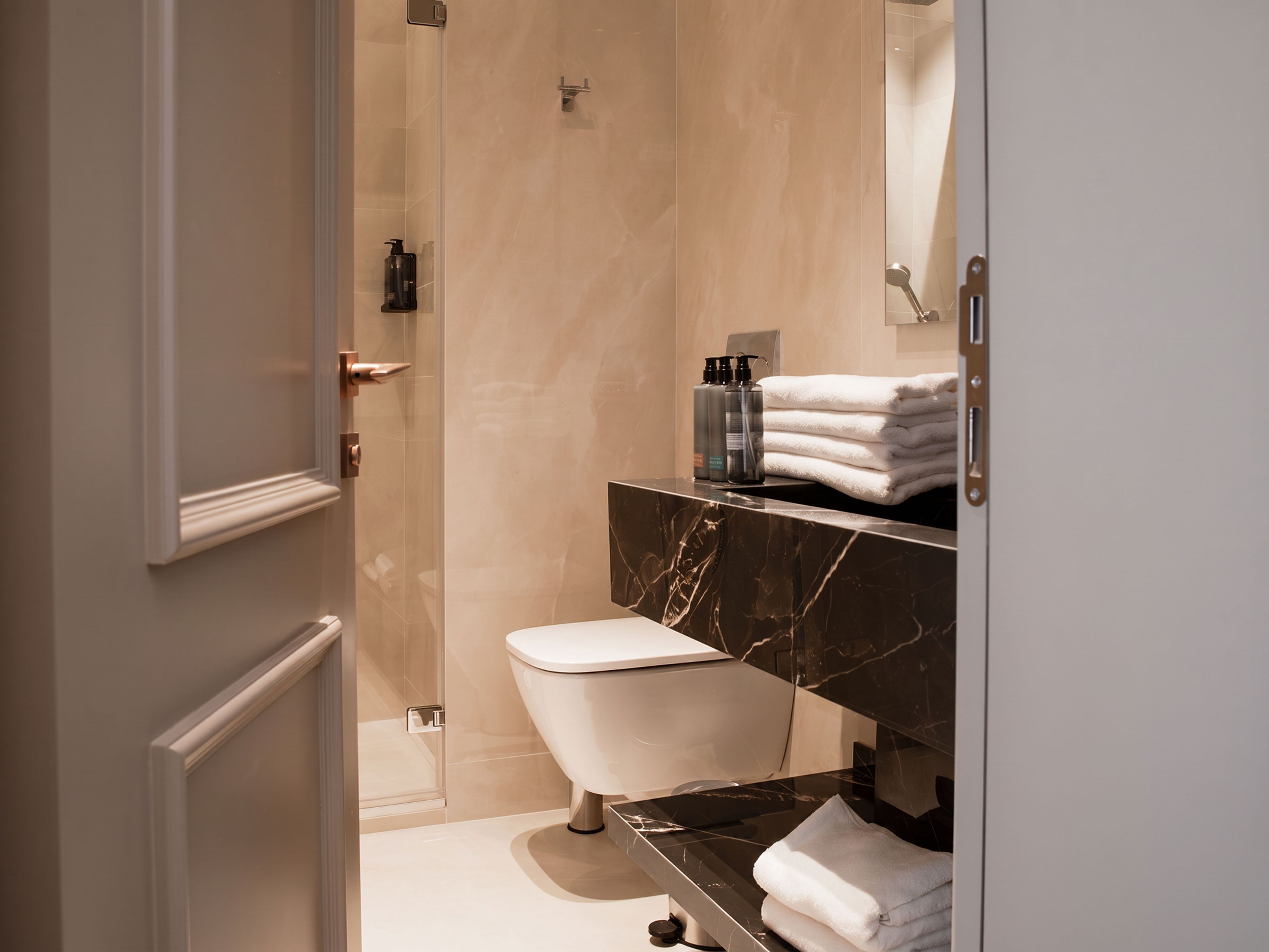 Un baño moderno con inodoro, lavamanos y zona de ducha.