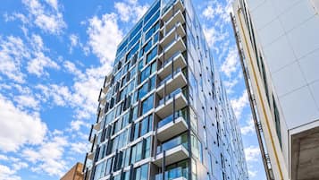 A modern high-rise building with multiple balconies and large windows.