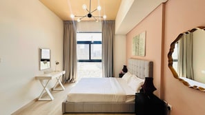 Una camera d'hotel con un letto grande, una scrivania, una sedia, uno specchio e vista sulla città.