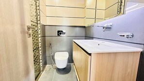 Un bagno piccolo con il water bianco, un lavandino e uno specchio.
