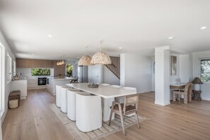 A spacious kitchen with a central island, pendant lighting, and a view of the outdoors. - Whale Watcher - elevated coastal escape (Lennox Head)