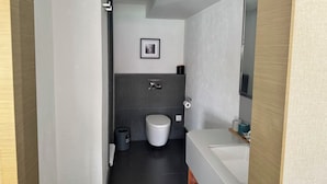 A modern bathroom with a toilet, sink, and a mirror. - Yiyi Zhenxuan Hostel (Shanghai)