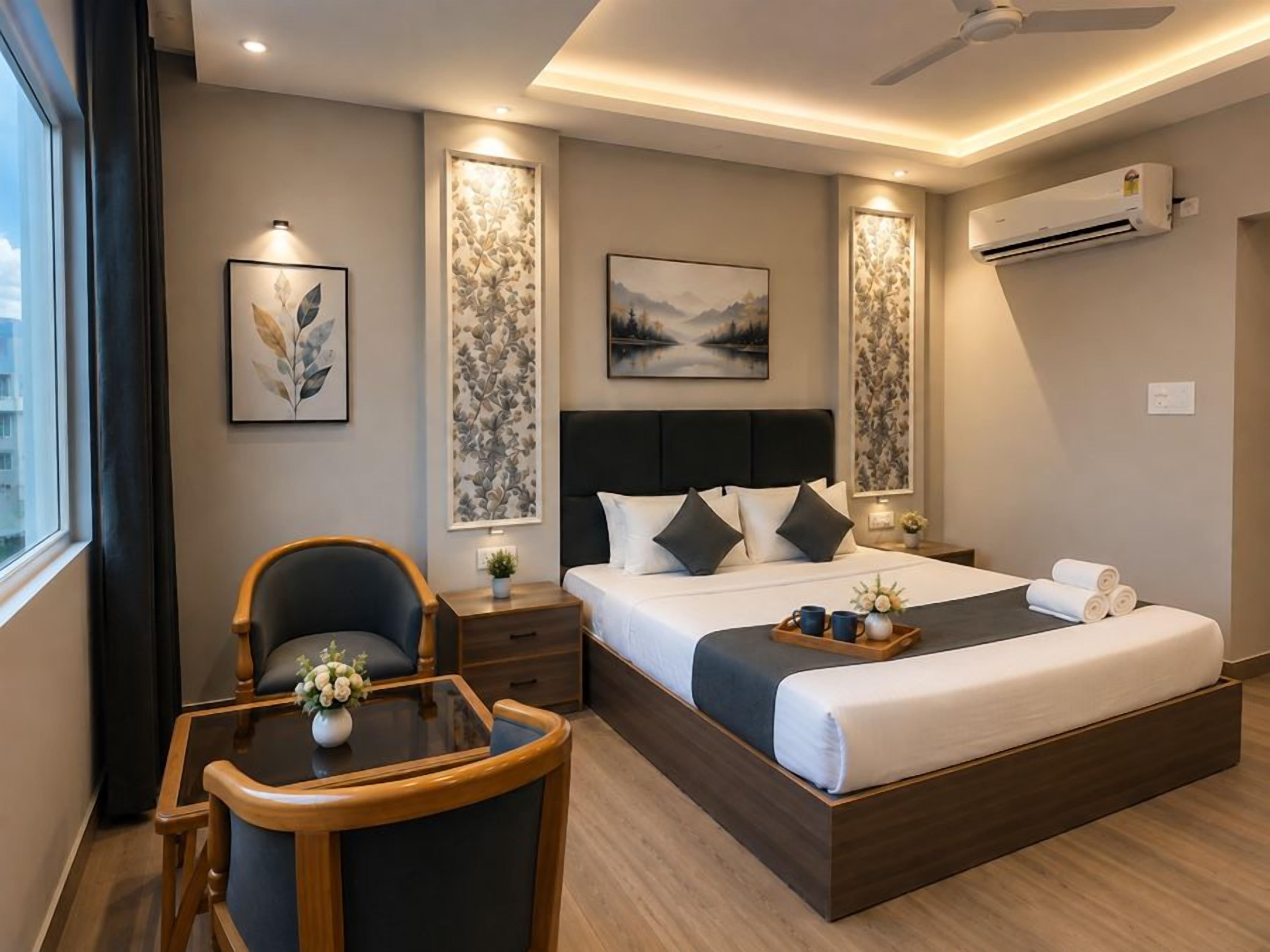 A modern hotel room with a large bed, a desk, and a chair.